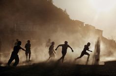 silhouettes of people playing soccer on a foggy field