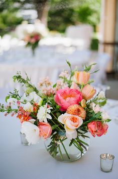 a vase filled with lots of flowers on top of a table