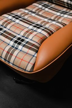 a brown and black chair with a plaid seat cover on it's back end