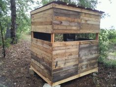 a small wooden structure in the woods