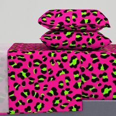 pink and green leopard print bedding with matching pillowcases on top of each other