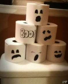 several rolls of toilet paper with faces drawn on them sitting on top of each other