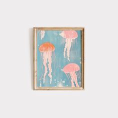 a painting with jellyfish on it in a wooden frame hanging on the wall next to a white wall