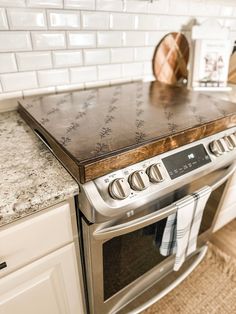 a stainless steel stove top sitting in a kitchen next to white cabinets and counter tops