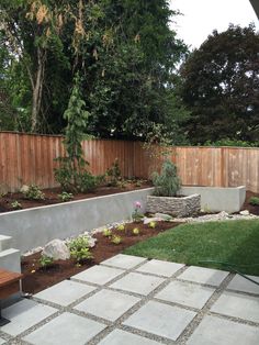 a backyard with a stone wall and wooden fence