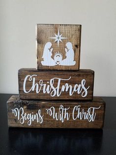 two wooden christmas signs sitting on top of each other