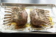 two cooked meats are on tin foil with tongs sticking out of the top