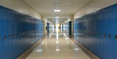 a long hallway with several blue lockers on both sides