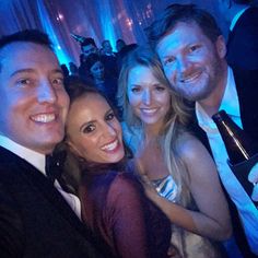 two men and one woman posing for the camera at a party with blue lights in the background