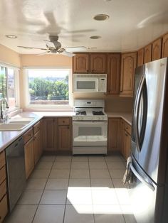 an empty kitchen with tile flooring and stainless steel appliances in the middle of it