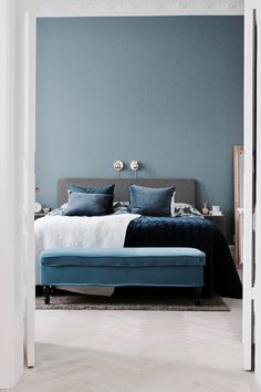 a bedroom with blue walls and white floors