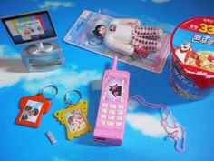 a pink cell phone sitting on top of a table next to other toys and accessories