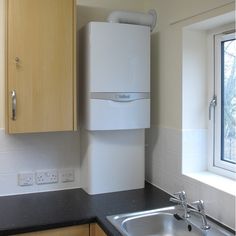 a kitchen with a sink, window and cupboards