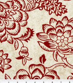 a red and white floral print on fabric with a ruler in front of it,