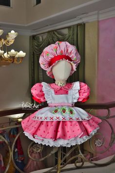 a doll is dressed in pink and white