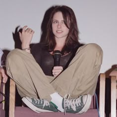 a woman sitting in a chair holding a microphone