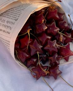 a bag full of dried cherries sitting on top of a white cloth covered table