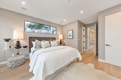 a bedroom with white bedding and wooden floors