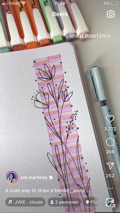 a notepad with some flowers on it next to markers and pens in front of them