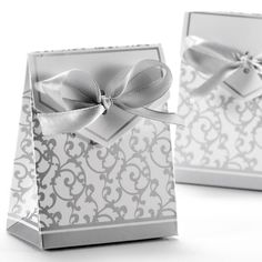 two white gift bags with silver bows on them