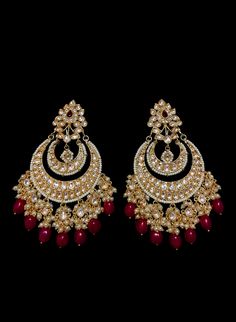 Neetri - Kundan Earrings with Ruby drops Graceful traditional Indian earrings made with hammered metal and plated with gold. This glamourous Kundan stone stud setting makes this earring jewelry one of a kind. Red Ruby gems add color and grace to this jewelry piece. Luxurious pearl drops enhance this piece making it perfect to be paired with any of your ethnic wear. Approximate earrings 3.5" Details: Handcrafted Metal: Metal Alloy, Gold Plated Stone: Kundan, Pearls & Ruby's Traditional / Mode Luxury Meenakari Bridal Earrings For Reception, Luxury Earrings For Anniversary And Diwali, Luxury Traditional Ruby Jhumkas, Luxury Bollywood Earrings For Navratri, Luxury Ruby Meenakari Jhumkas, Hand Set Gold Plated Earrings, Festive Gold Plated Drop Earrings, Festive Gold-plated Bridal Earrings, Red Kundan Dangle Jewelry