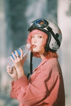 a woman wearing a helmet and holding a water bottle