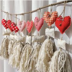 many hearts are hanging on the wall with name tags attached to them and tassels