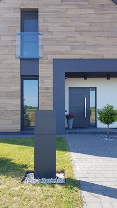 a modern house with a large front door and two windows on the side of it