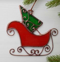 a metal ornament with a christmas tree on it's sleigh