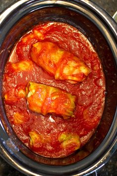 two pieces of meat covered in marinara sauce inside an instant pressure cooker pot