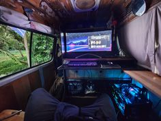 the inside of a vehicle with two monitors on it's wall and windows open