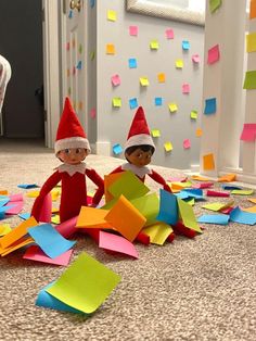 two elfs sitting on the floor surrounded by post it notes