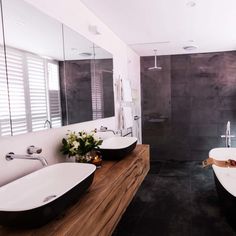 a bathroom with two sinks and a large mirror on the wall next to each other