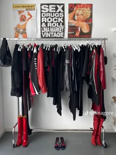 there is a rack with clothes and shoes hanging on the wall next to a pair of red boots