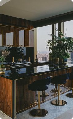 a kitchen with two bar stools next to an island and large window overlooking the city