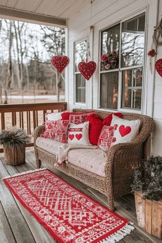 a couch and rug on a porch with hearts hanging from the ceiling