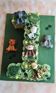 there is a cake with animals on it that looks like the letter i made out of fondant