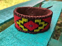 a beaded bracelet sitting on top of a wooden bench