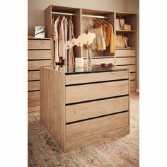 a wooden dresser with drawers and clothes on it