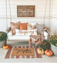 the porch is decorated with fall decorations and pumpkins