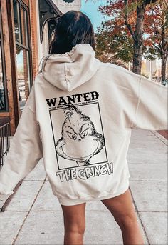 a woman walking down the street wearing a white hoodie with an image of a gorilla on it