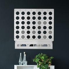 a white cabinet sitting next to a potted plant on top of a wooden table