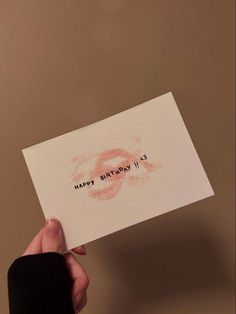 someone holding up a piece of paper with the words happy birthday written on it in red ink