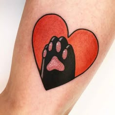 a dog paw and heart tattoo on the leg