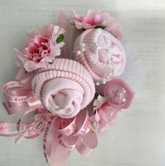 a bouquet of pink flowers and baby shoes