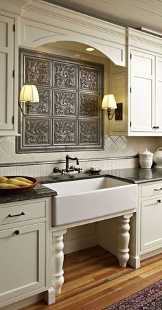 a kitchen with white cabinets and black counter tops, along with a large window over the sink