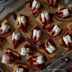 several pieces of bread with marshmallows and sauce on them sitting on a baking sheet