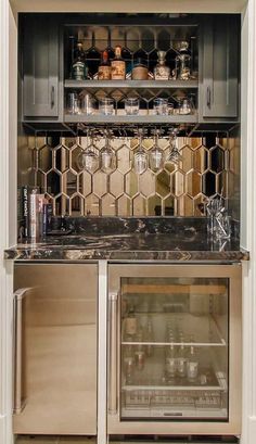 an open cabinet in the corner of a kitchen with many bottles and glasses on it