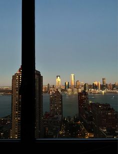 a view of the city from a high rise building at night, looking out on the water