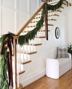 the stairs are decorated with greenery for christmas